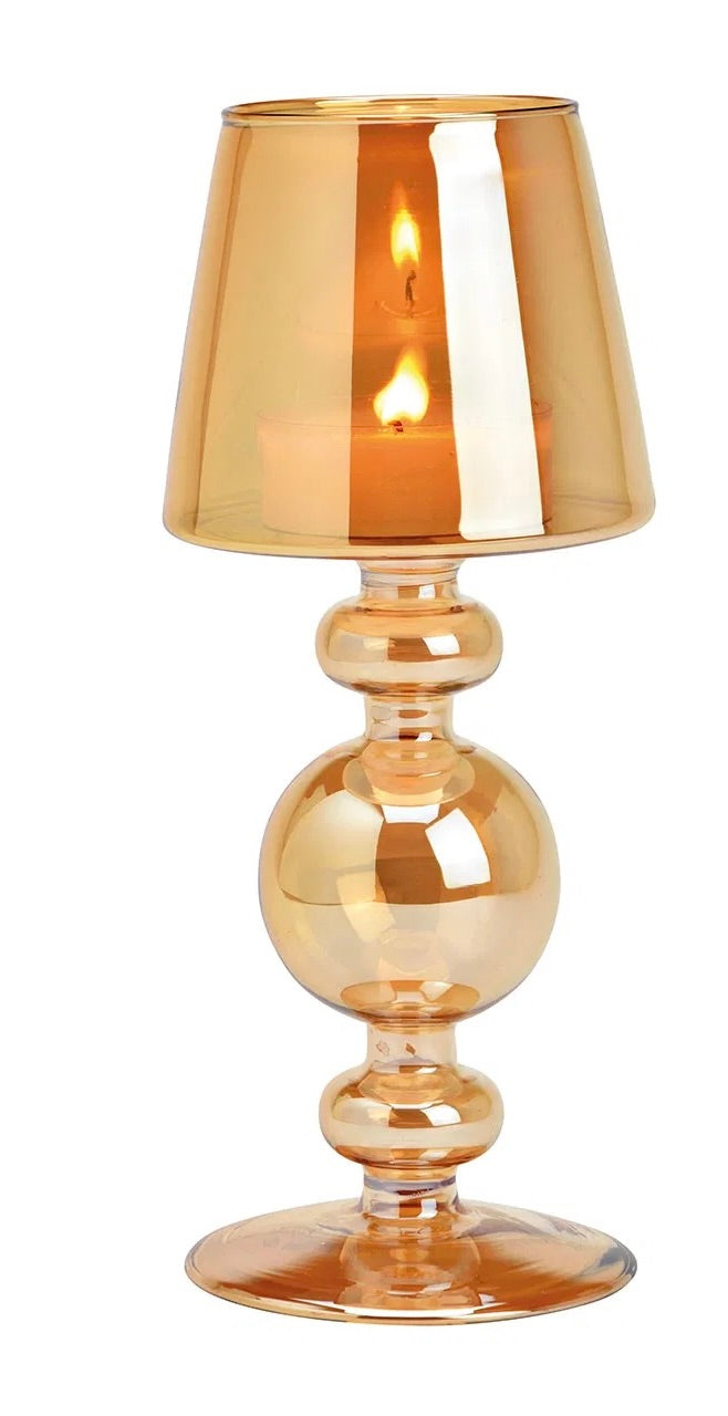 Warm amber goblet-style glass candle holders with lit candles inside, against a white background.