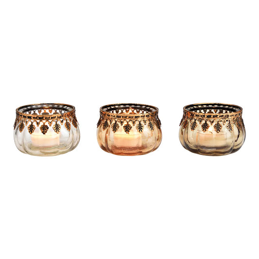 Three brown glass candle holders with floral patterns, displayed in a set, with candles.
