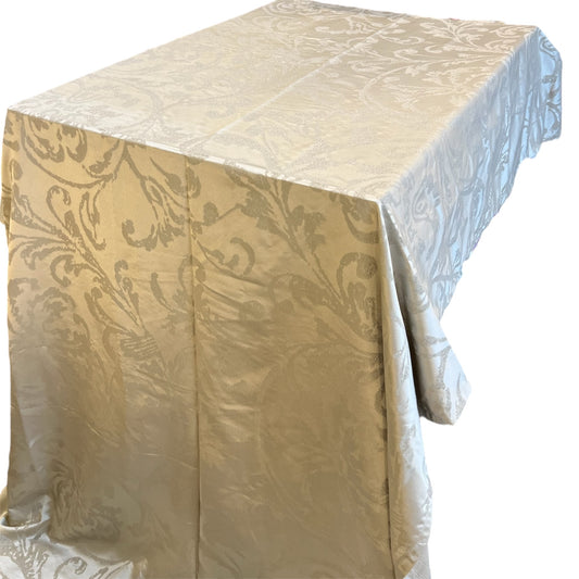 A beige tablecloth with a floral pattern draped over a table.