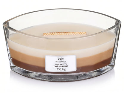 WoodWick Café Sweets Trilogy candle in a clear glass jar with an open lid.