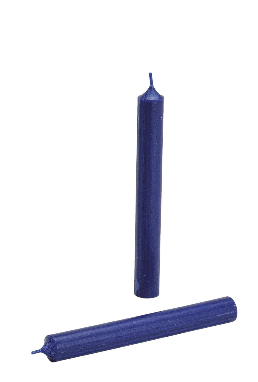 Two dark blue candles, one standing upright and one lying horizontally, on a white background.
