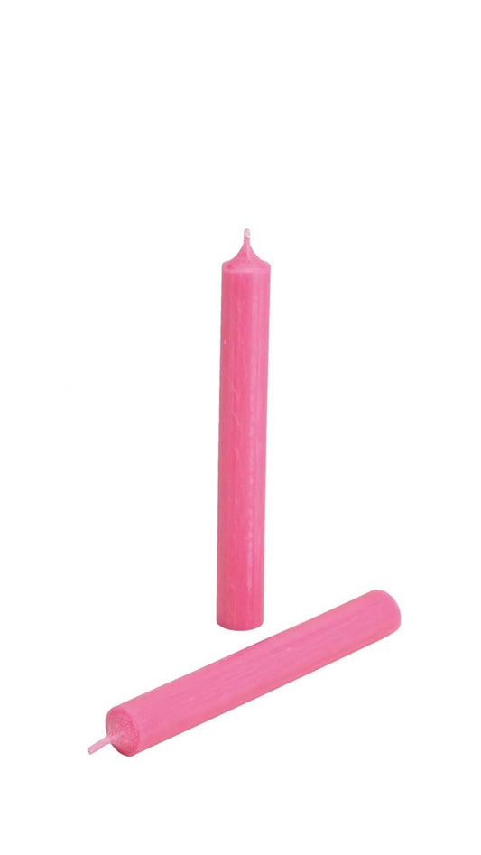 A pink colored candle on a white background.
