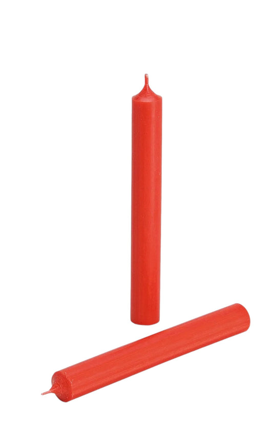 A red colored candle with a solid shape and a wick, placed on a white background.