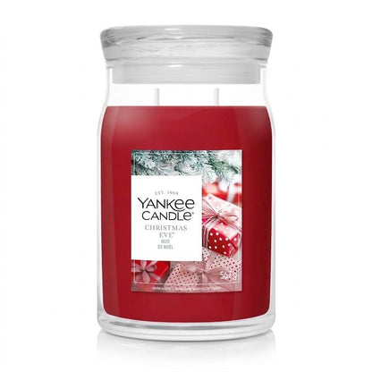 **Yankee Candle Christmas Eve jar candle with festive red wax and wrapped gift box label artwork on a white background.**