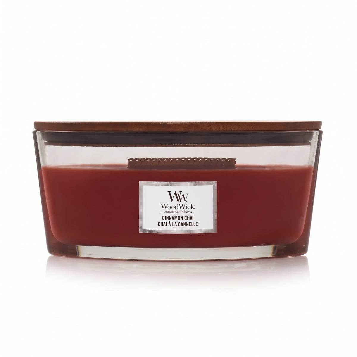 WoodWick Cinnamon Chai candle in a clear glass jar with a wooden lid.