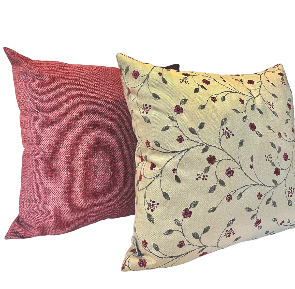 Pair of decorative throw pillows featuring a solid crimson red cushion alongside a cream cushion with a red floral vine pattern against a white background.