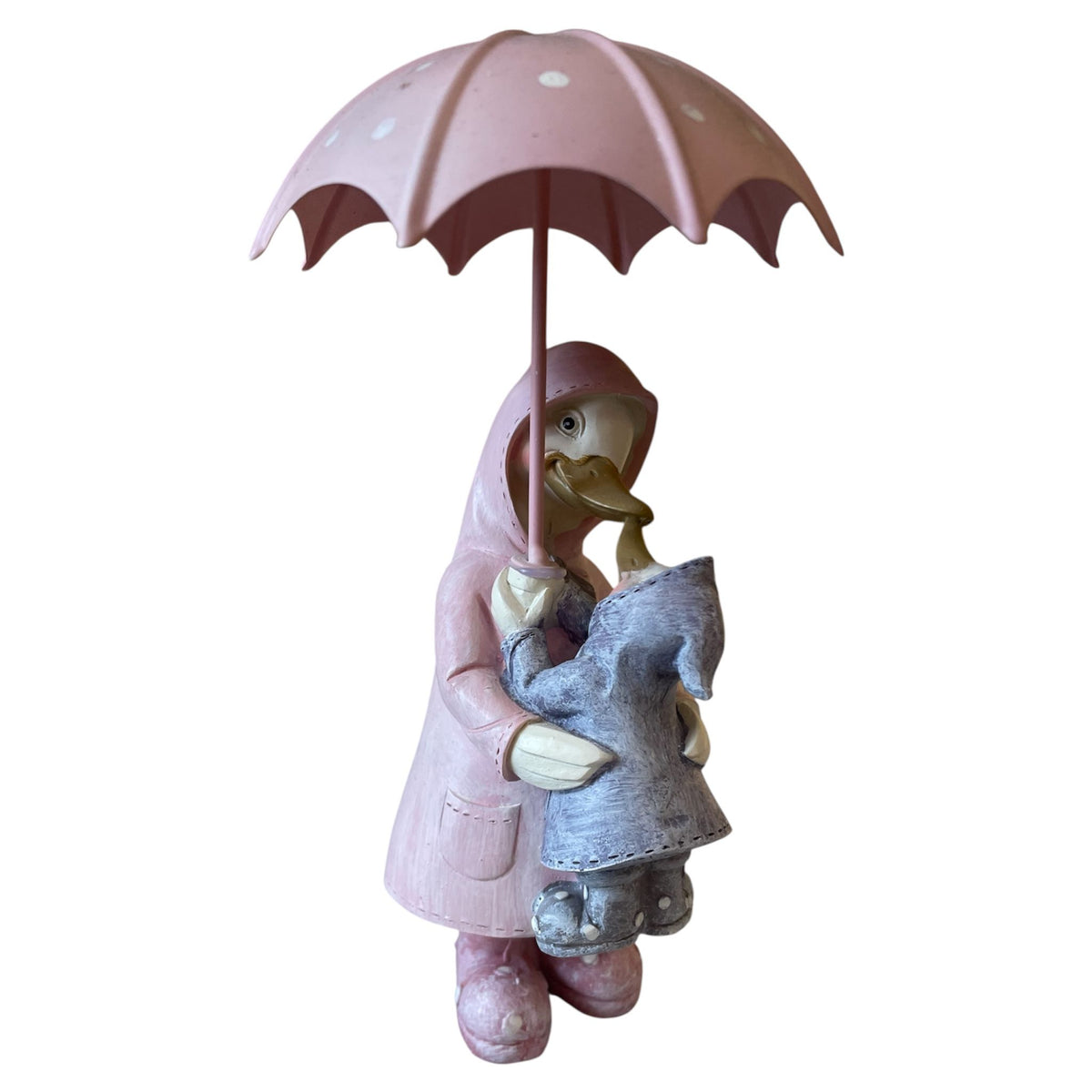 Statue of a child holding a pink umbrella with a duck under a white background