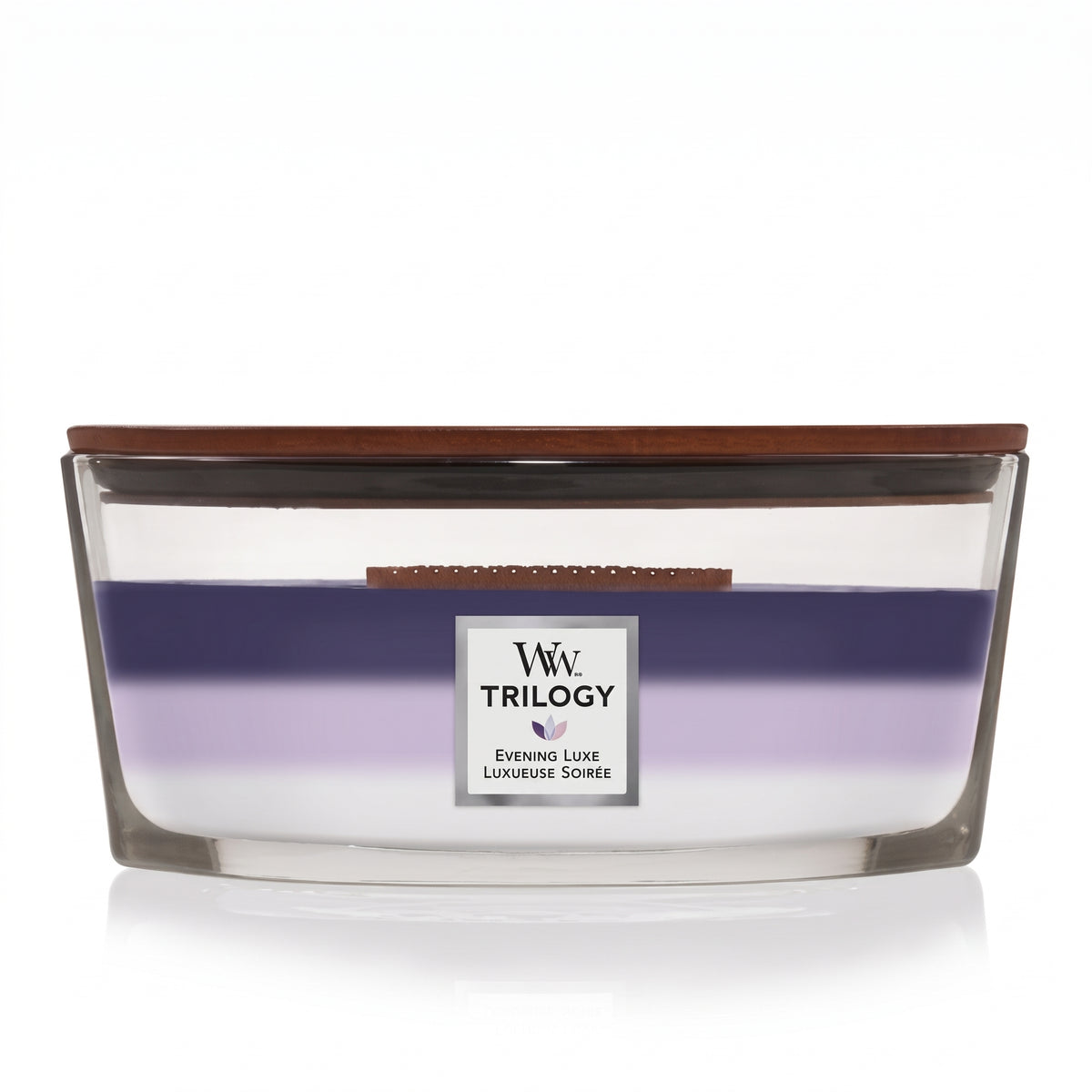 WoodWick Evening Luxe Trilogy ellipse candle in a clear glass jar with a wooden lid.