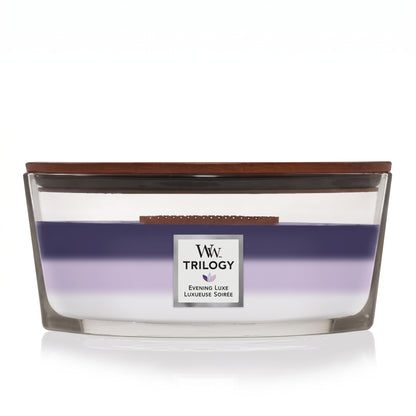WoodWick Evening Luxe Trilogy ellipse candle in a clear glass jar with a wooden lid.