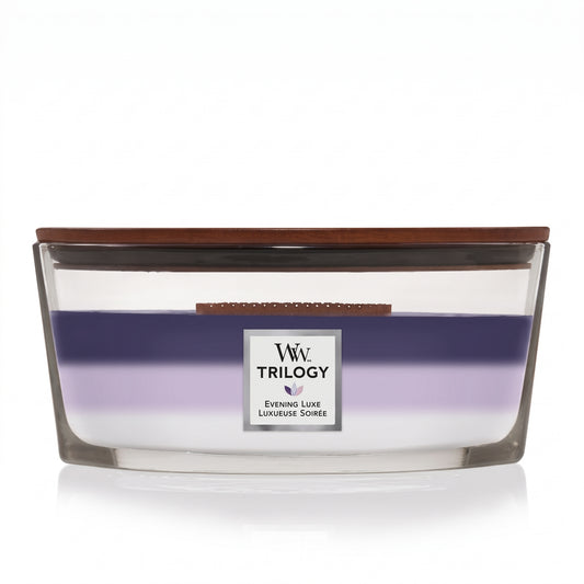WoodWick Evening Luxe Trilogy ellipse candle in a clear glass jar with a wooden lid.