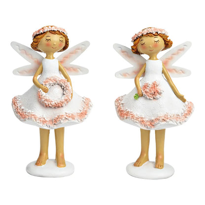 Two ceramic figurines of fairies in white and pink colors, each holding a small floral wreath.
