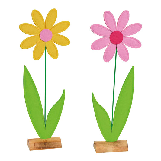 Two artificial flowers with pink and yellow petals respectively, on wooden stands.