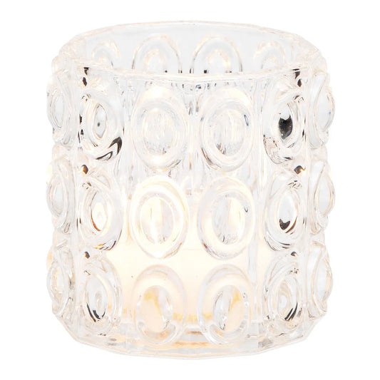 A clear glass windlight with a geometric pattern, intended for holding a candle to provide illumination.