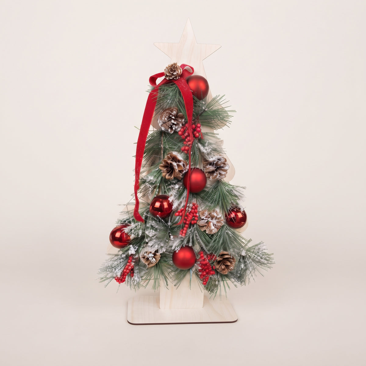 Handmade wooden star Christmas tree centerpiece decorated with pine branches, pinecones, red berries, and red ornaments.