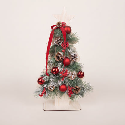 Handmade wooden star Christmas tree centerpiece decorated with pine branches, pinecones, red berries, and red ornaments.