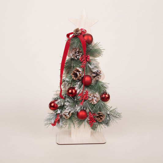 Handmade wooden star Christmas tree centerpiece decorated with pine branches, pinecones, red berries, and red ornaments.