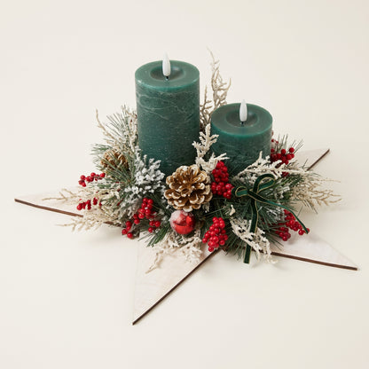 Handmade green pillar candle centerpiece on a white wooden star with pinecones and berries