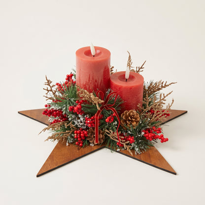 Handcrafted red pillar candle centerpiece featuring natural pinecones and green foliage on a wooden star base