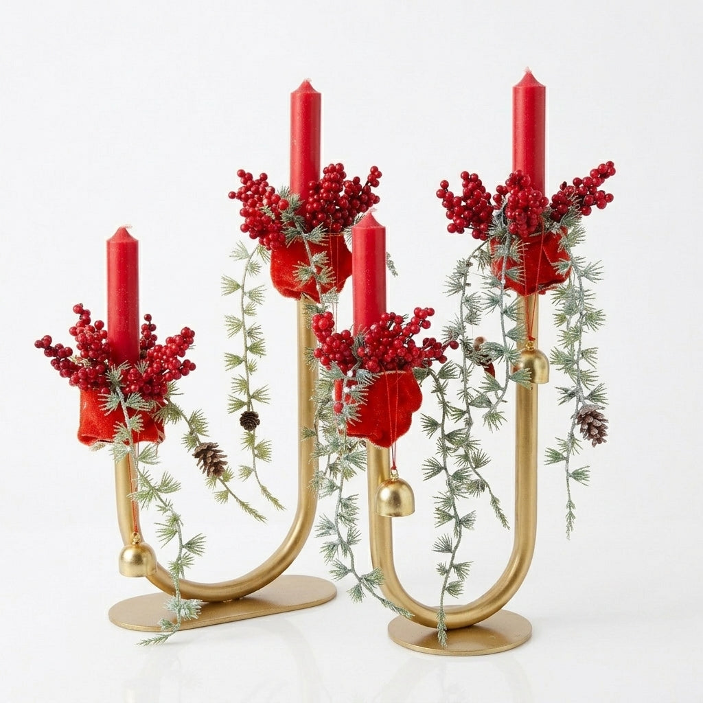 Handmade gold candelabra centerpiece with red pillar candles, evergreen branches, berries, and gold bells for Christmas table decor, designed by Inas.