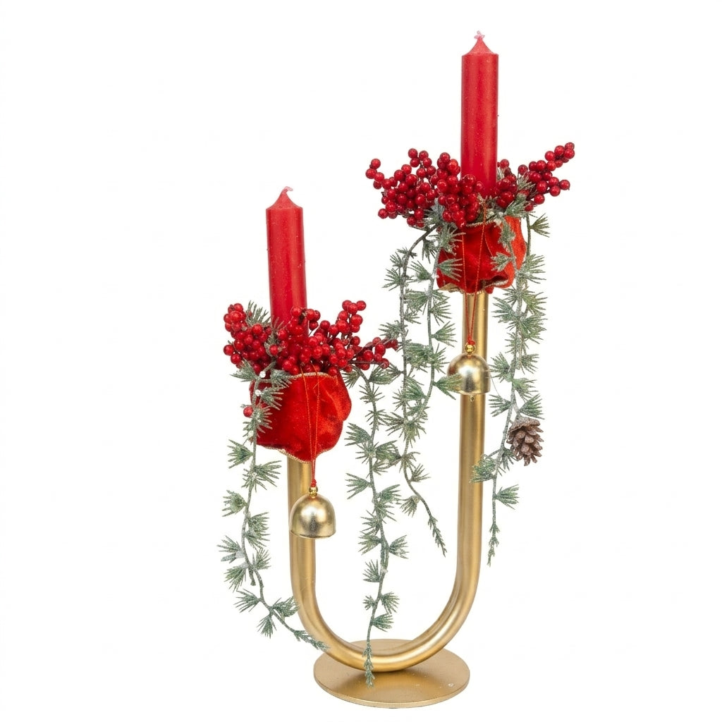 Handmade gold candelabra centerpiece with red pillar candles, evergreen branches, berries, and gold bells for Christmas table decor, designed by Inas.