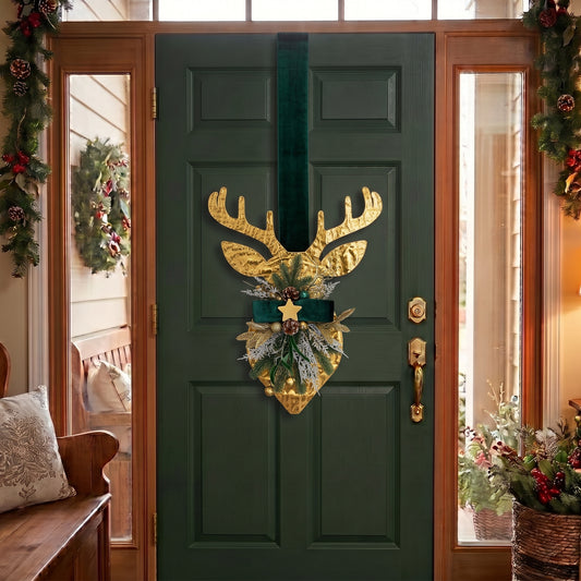 Handcrafted two-sided golden deer holiday door hanger featuring a festive red plaid tartan ribbon, frosted pine branches, pinecones, berries, and a golden bell, hanging on a classic green front door.