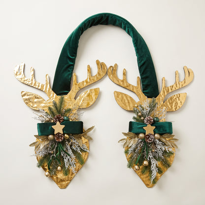 Handcrafted two-sided wooden deer holiday door hanger featuring a festive red plaid tartan ribbon, frosted pine branches, pinecones, berries, and a golden bell, against a white baclground