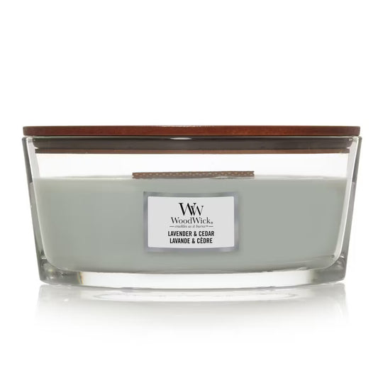 WoodWick Lavender & Cedar Ellipse Jar Candle with light sage green wax, a wooden wick, and a wooden lid centered against a clean white background.