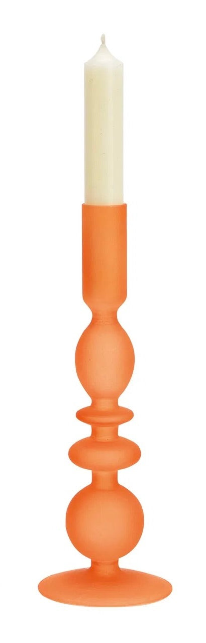 Light Orange glass candle holder, with a white candle on top.