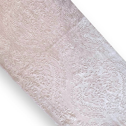 A close-up image of a light pink fabric with a beige paisley pattern.