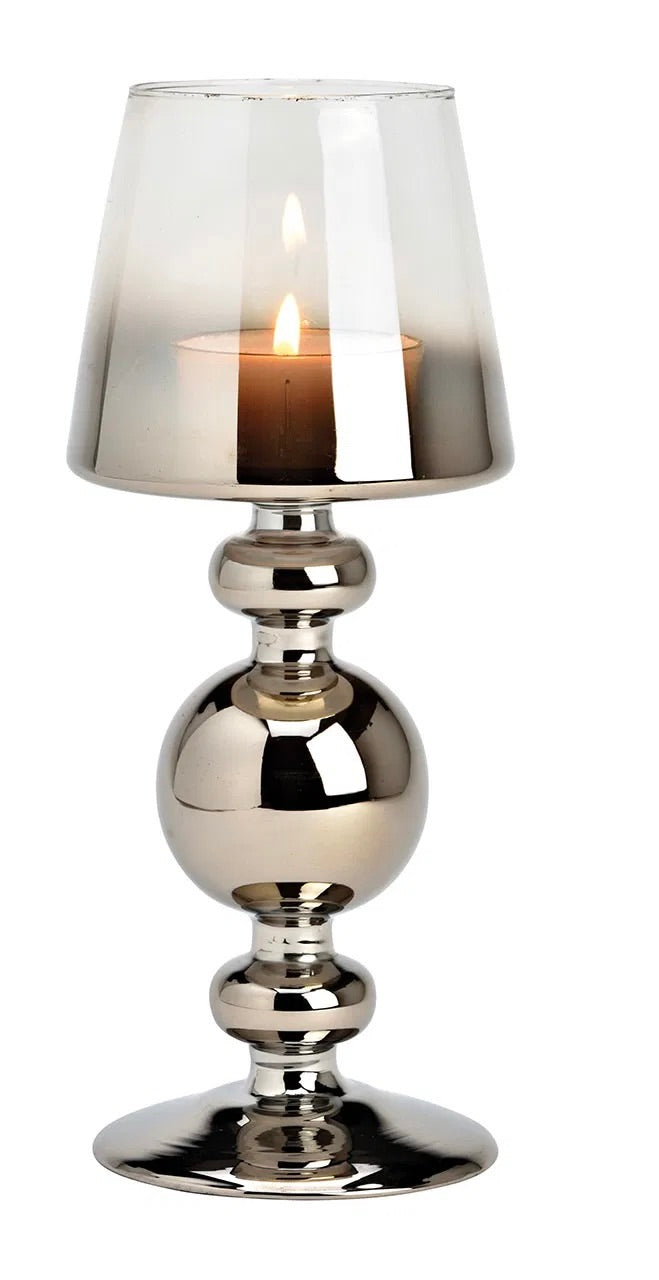 Metallic silver goblet-style glass candle holders with lit candles inside, against a white background.