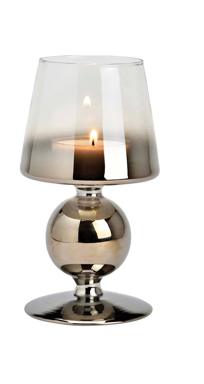 Metallic silver goblet-style glass candle holders with lit candles inside, against a white background.
