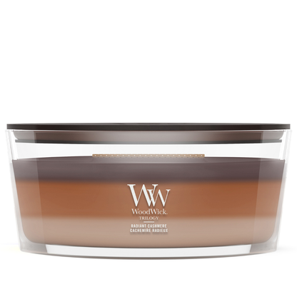 WoodWick Radiant Cashmere trilogy ellipse candle in a clear glass jar with a wooden lid.