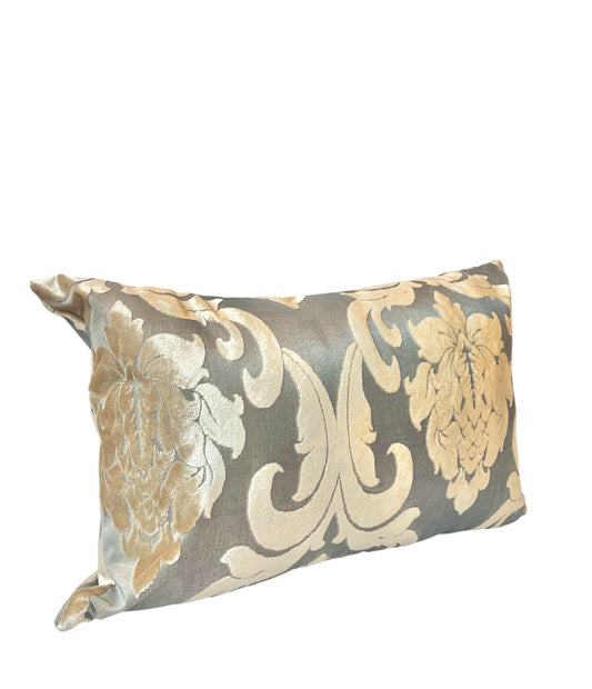 A rectangular throw pillow with a gold and gray floral pattern.