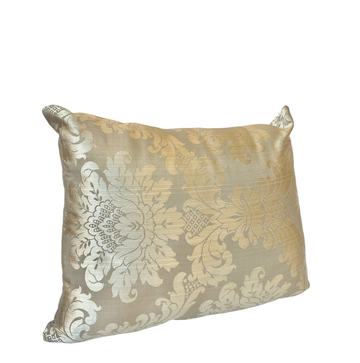 A rectangular throw pillow with a gold and beige floral pattern.
