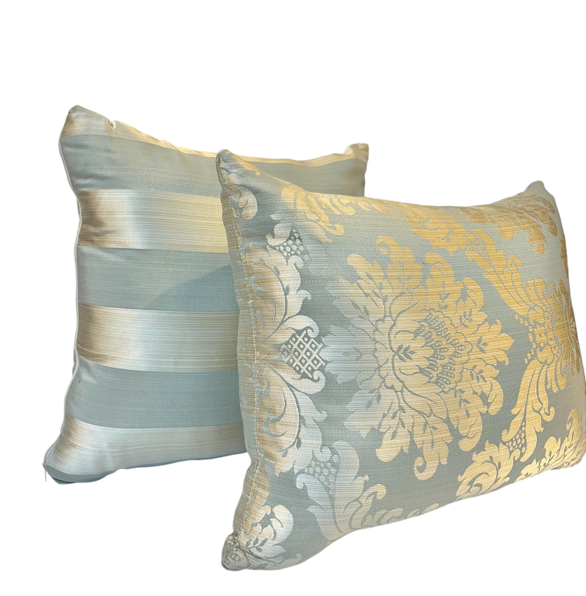 Pair of rectangular decorative throw pillows featuring an ornate golden floral damask pattern and soft blue fabric against a white background.