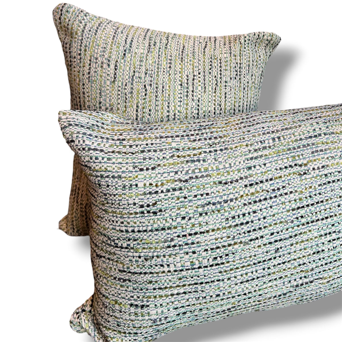 Set of two textured tweed decorative pillows, featuring a rectangular lumbar pillow in front of a matching square cushion in woven sage green, cream, grey, and soft blue tones against a white background.