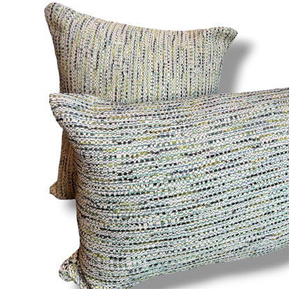 Set of two textured tweed decorative pillows, featuring a rectangular lumbar pillow in front of a matching square cushion in woven sage green, cream, grey, and soft blue tones against a white background.