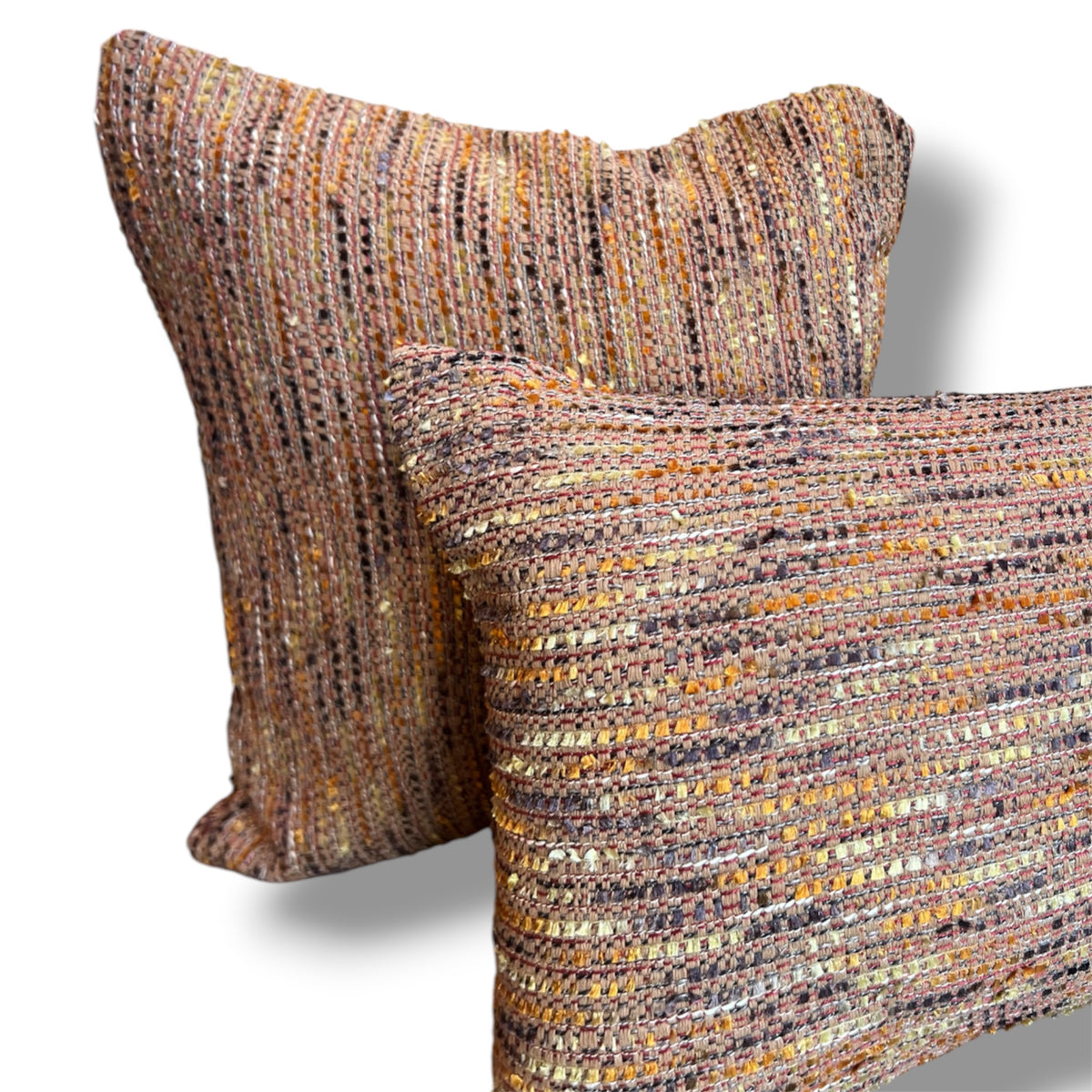 Set of two textured tweed decorative pillows, featuring a rectangular lumbar pillow in front of a matching square cushion in woven terracotta, ochre yellow, brown, and soft purple tones against a plain white background.
