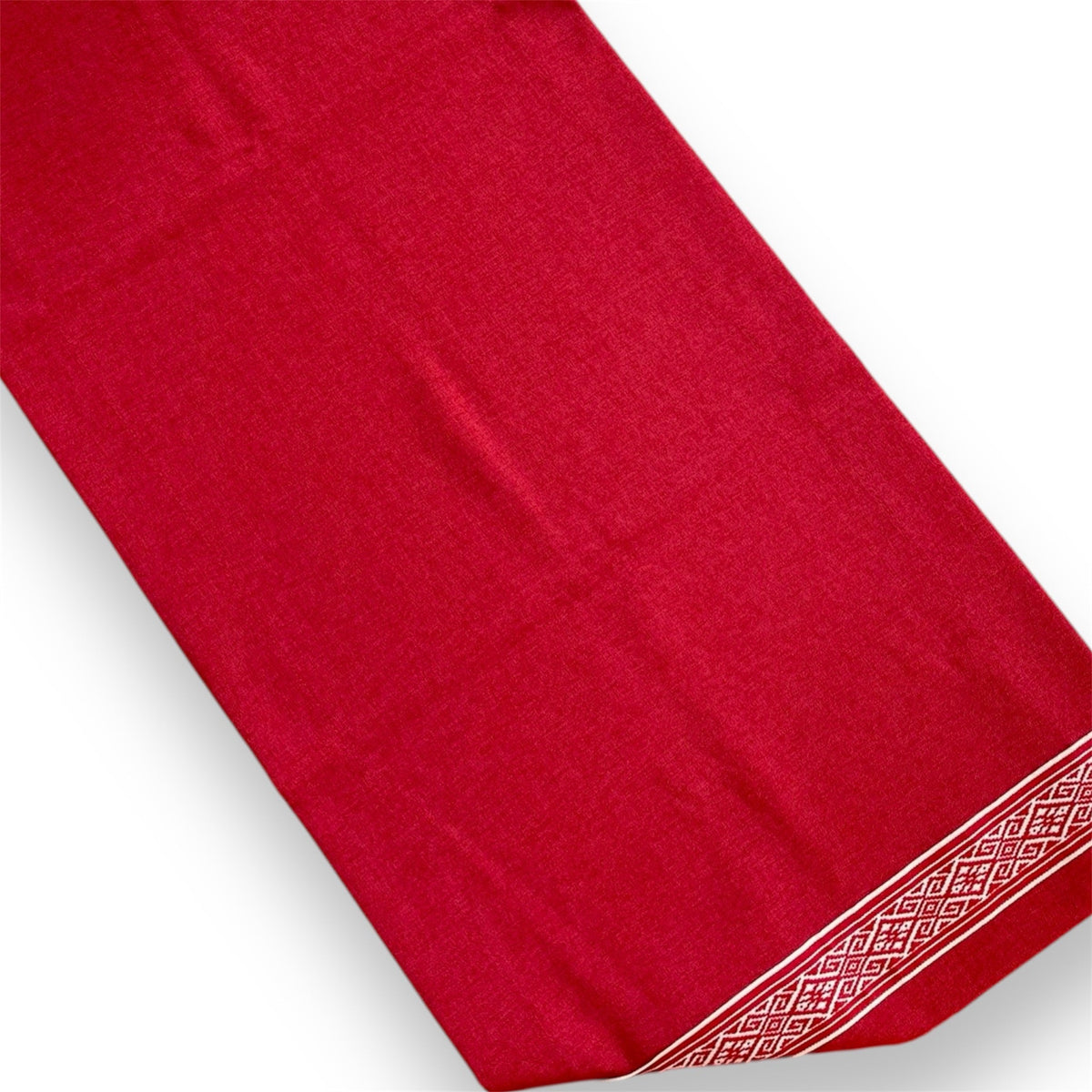 A red runner with a white geometric pattern on the border.