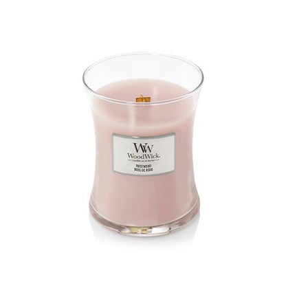 WoodWick scented candle in a clear glass jar with pale pink wax and a white front label, photographed on a clean white background.
