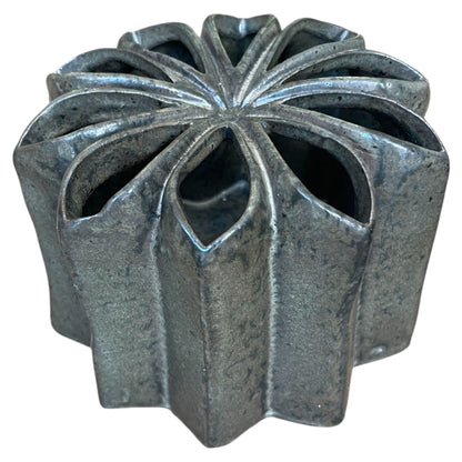 Decorative metal vase with a unique geometric design on a white background