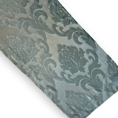 A silver-blue patterned runner with a floral design, likely used for decorative purposes.