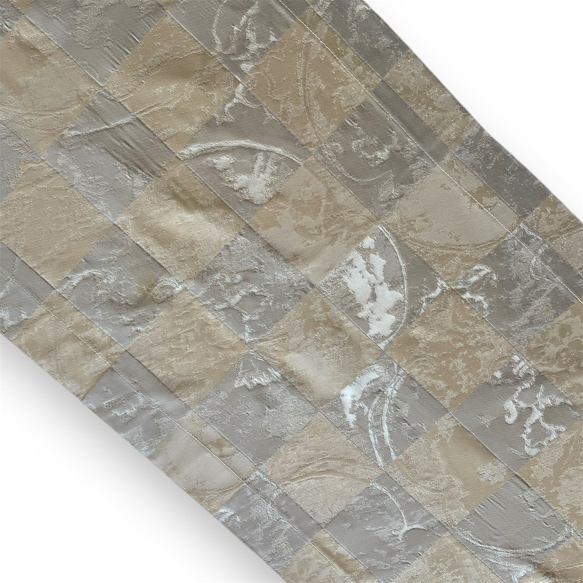 A table runner with a pattern that includes cubes in silver and gold colors.