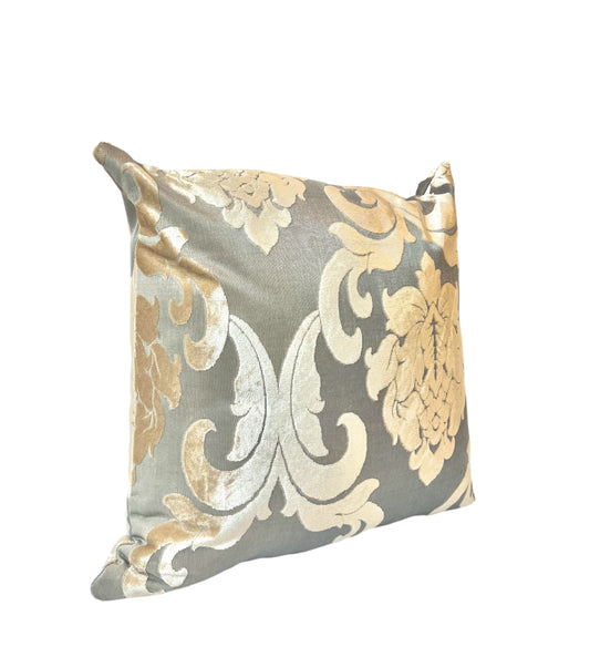 A square throw pillow with a gold and gray floral pattern.