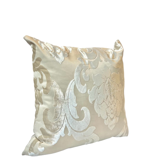 A square-shaped throw pillow with a silver and beige floral pattern.