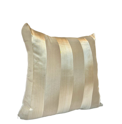 A square throw pillow with silver and golden stripes on a white background.