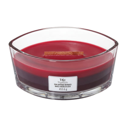A large red wax candle in a clear glass bowl with a white label reading WickRock Son Rempée Berries, on a plain white background.