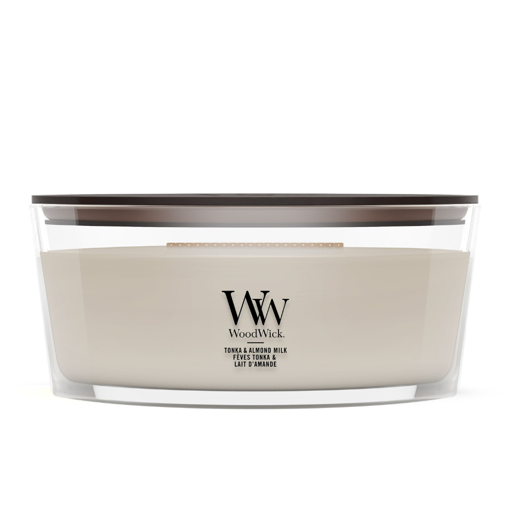 Soft Wool & Amber scented jar candle surrounded by cozy knit blanket layers.