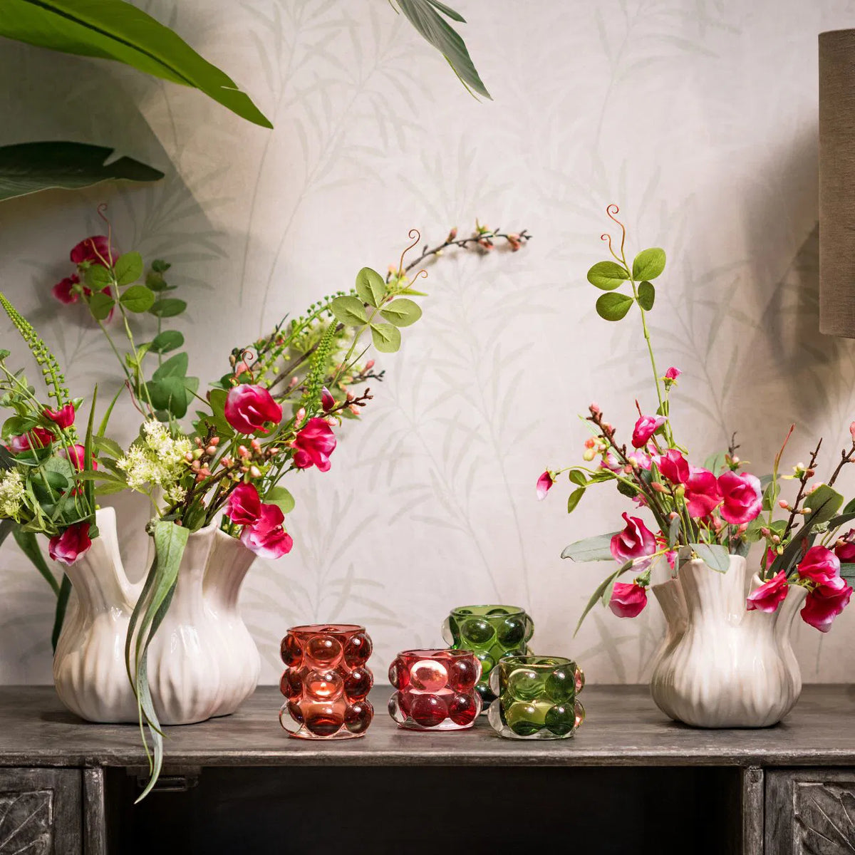 Two Bubble Glass Windlights, one pink and one green, with a bubble pattern design in decorative atmosphere background