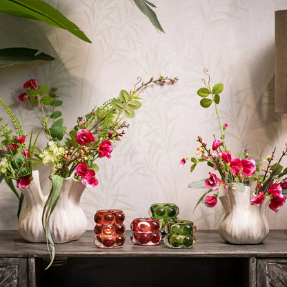 Two Bubble Glass Windlights, one pink and one green, with a bubble pattern design in decorative atmosphere background